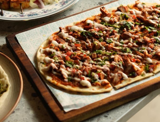 Flatbread topped with chicken and herbs